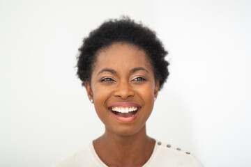 Close up happy young African American woman laughing and glancing by white isolated background