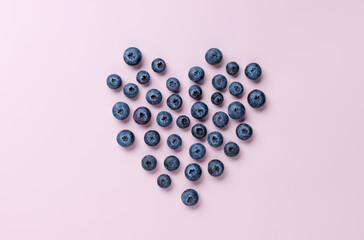 Heart shaped blueberries on color background. Healthy berry organic food. Love, Valentines Day concept.