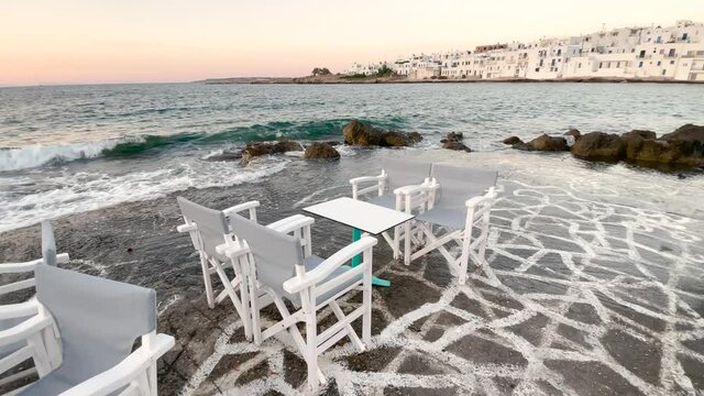 Picturesque waterfront restaurant cafe in cyclades island, traditional greek tavern, romantic atmosphere, Paros Greece summer vacation relaxation an outdoor near the Mediterranean Sea Paros Greece