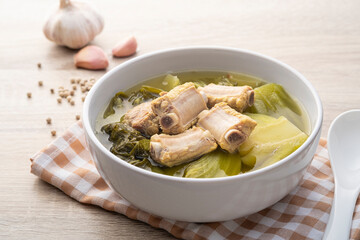 Pickled lettuce soup with pork spare ribs in white bowl