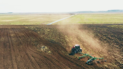 4K Aerial Elevated View.Tractor Plowing Field. Beginning Of Agricultural Spring Season. Cultivator Pulled By A Tractor In Countryside Rural Field Landscape