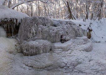 frozen winter waterfall in nature forest covered with ice and snow