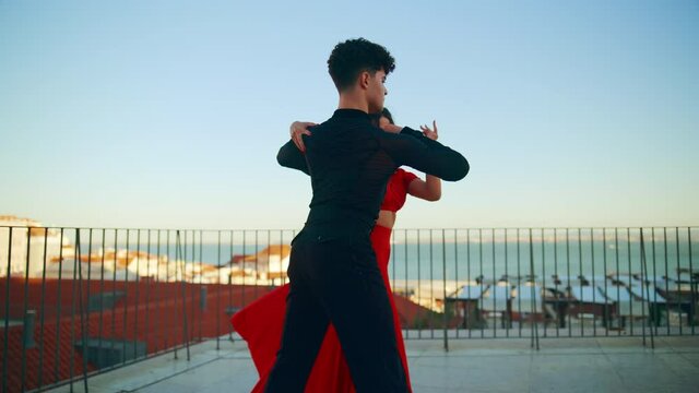 Beautiful Couple Dancing a Latin Dance Outside the City with Old Town in the Background. Sensual Dance by Two Professional Dancers on a Sunset in Ancient Culturally Rich Tourist Location.