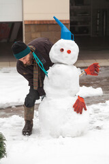 Man with beard sculpts  snowman figure