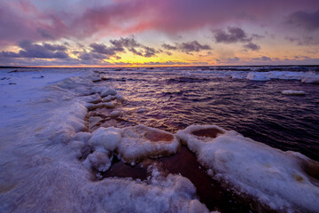 sunset in winter small river frozen snow in the beach