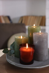 Fototapeta na wymiar Beautiful burning candles on wooden table indoors, space for text