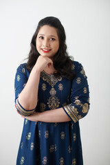 Portrait of smiling woman standing against white wall and looking at camera