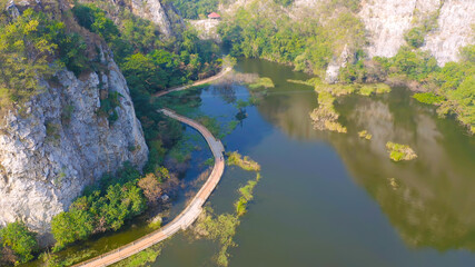 Fototapeta na wymiar Aerial view of Khao Ngu Stone. National park with river lake, mountain valley hills, and tropical green forest trees at sunset in Ratchaburi, Thailand in travel trip. Natural landscape background.