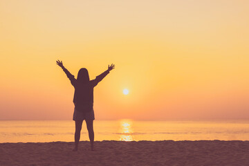 Copy space of woman rise hand up on sunset sky at beach and island background.