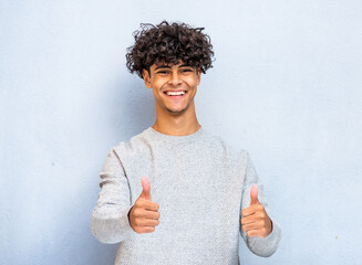 cool smiling North African young man with thumbs up hand sign