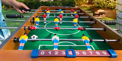 Two kicker game players have fun for playing table football soccer, Soccer table game or Football game toy in the park, - obrazy, fototapety, plakaty