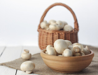 plate and basket with mushrooms on a white background of boards close-up