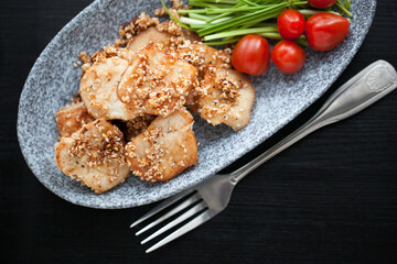 asian sesame chicken dish on a plate with garlic sprouts