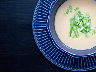 creamy chicken soup puree in a dark blue bowl top view