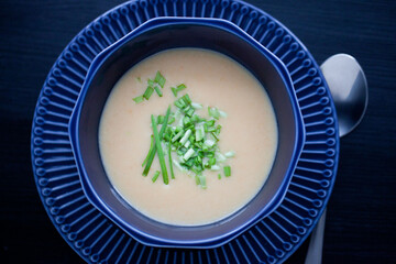 creamy chicken soup puree in a dark blue bowl top view