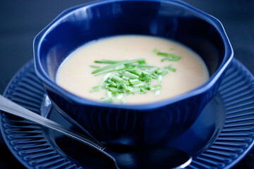 creamy chicken soup puree in a dark blue bowl 