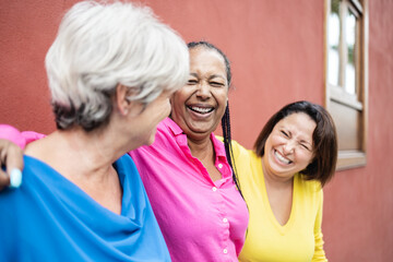Multiracial happy senior women having fun hugging together outdoor - Elderly friendship people concept