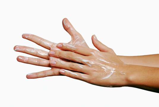 Appying body skin cream on hands closeup on white background.