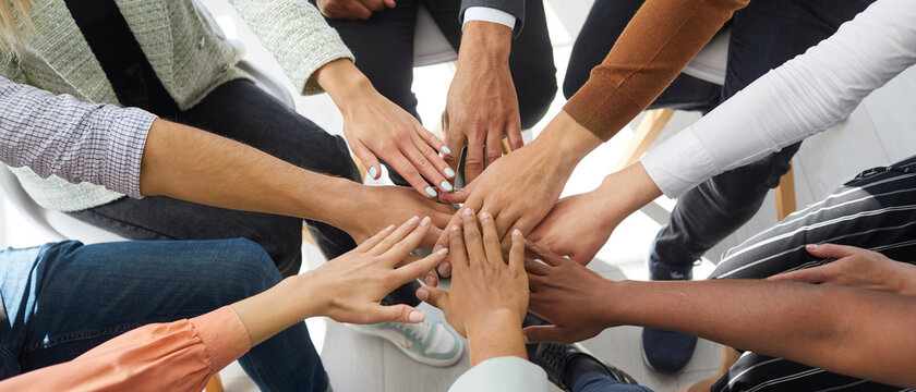 Narrow banner of multiracial people stack hands motivated for shared business success or goal achievement. Diverse intentional employees involved in teambuilding activity. Teamwork, cooperation.