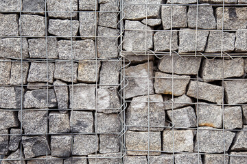 Cube shape Grey stones in Basket Gabion Wall, wire fence filled with cobblestones background