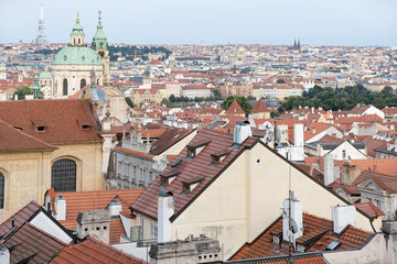 Obraz premium Rooftops in the old town in Prague. Aged Tiled covered Roofs with brick chimneys. Above city