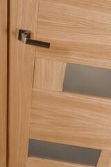 Naklejka na ściany i meble Metal door handle on closed natural wooden door