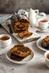 Homemade chocolate pumpkin cupcake with tea on a light gray background. Family tea party.