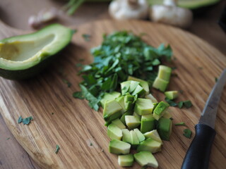 Healthy food concept. Fresh green vegetables on the table, salad, avocado and parsley on a wooden cutting board.