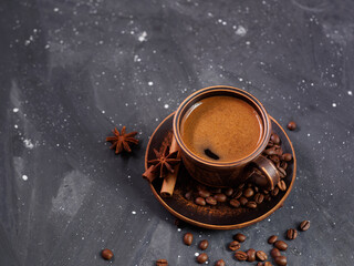 A cup of espresso coffee and roasted coffee beans on a black background
