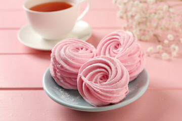 Delicious zephyrs served with tea on pink wooden table