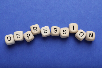 Word Depression made of wooden cubes on blue background, flat lay