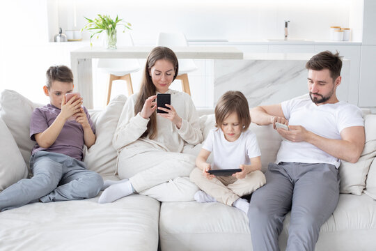 Family with smartphones at home