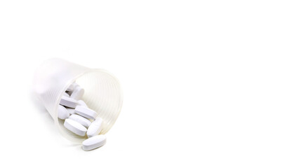 Composition with pills on the table. Heap of open medicines on a white paper background.