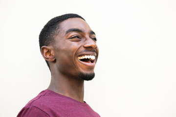 side portrait laughing young black man against white background