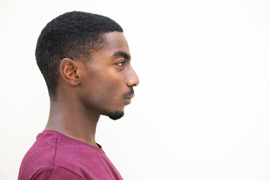 Close up profile serious young african american man staring by isolated white background
