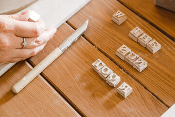 Wooden stencil and sculpting knife lie on the table