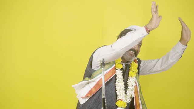 Indian politician greeting or waving hands to people in front microphone during by poll elections - concept of election campaign, political strategies and hydrama.