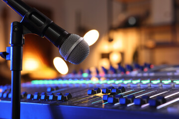 Microphone near professional mixing console in radio studio, closeup