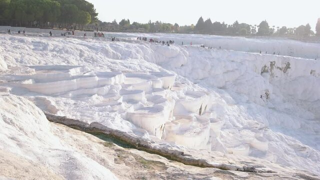 Natural travertine pools and terraces. Tourists at Pamukkale park.