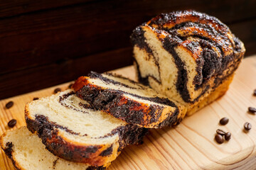Homemade poppy roll on the wooden background. Close-up, selective focus