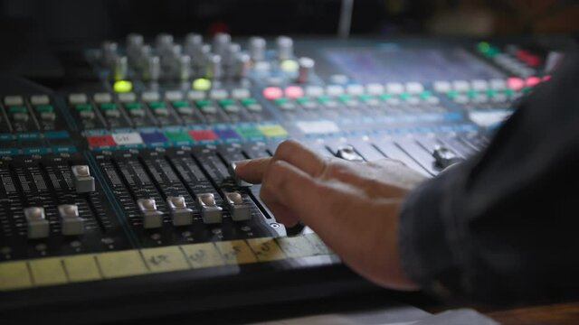 professional audio mixing console radio and TV broadcasting, sound producer hand is using faders