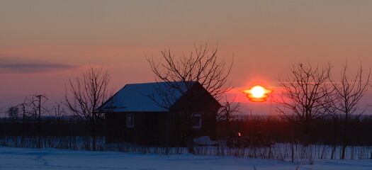 Sunset among the fields in winter scenery.