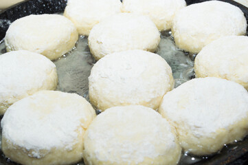 The process of making fresh pastries. Cottage cheese cheesecakes in a frying pan.