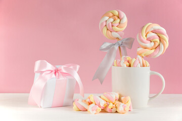 Sweet marshmallows on a pink pastel background. Childhood and birthday concept.