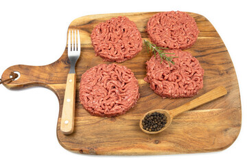 several raw hamburgers on a cutting board