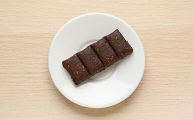 White plate with delicious and healthy hematogen bar  on wooden table, top view