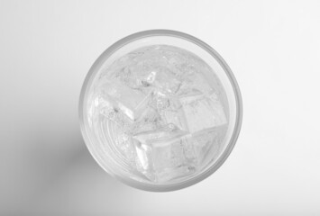 Glass of soda water with ice isolated on white, top view