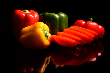 Papryka słodka w trzech kolorach. Czerwona, żółta i zielona. Kompozycja zdrowa żywność dla tła jako przepis kulinarny. Tapeta zdrowa żywność przedstawiająca papryczki.