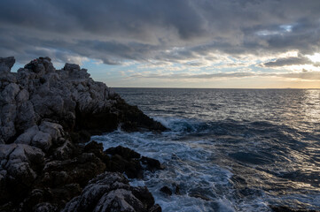 Paysage marin du rivage méditerranéen au Cap de Nice en hiver avec des vagues et des rochers au coucher du soleil