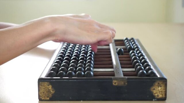 close up of a person using old abacus with right hand